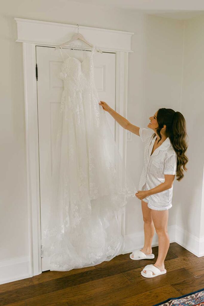 bridal gown on a hanger with bride getting ready