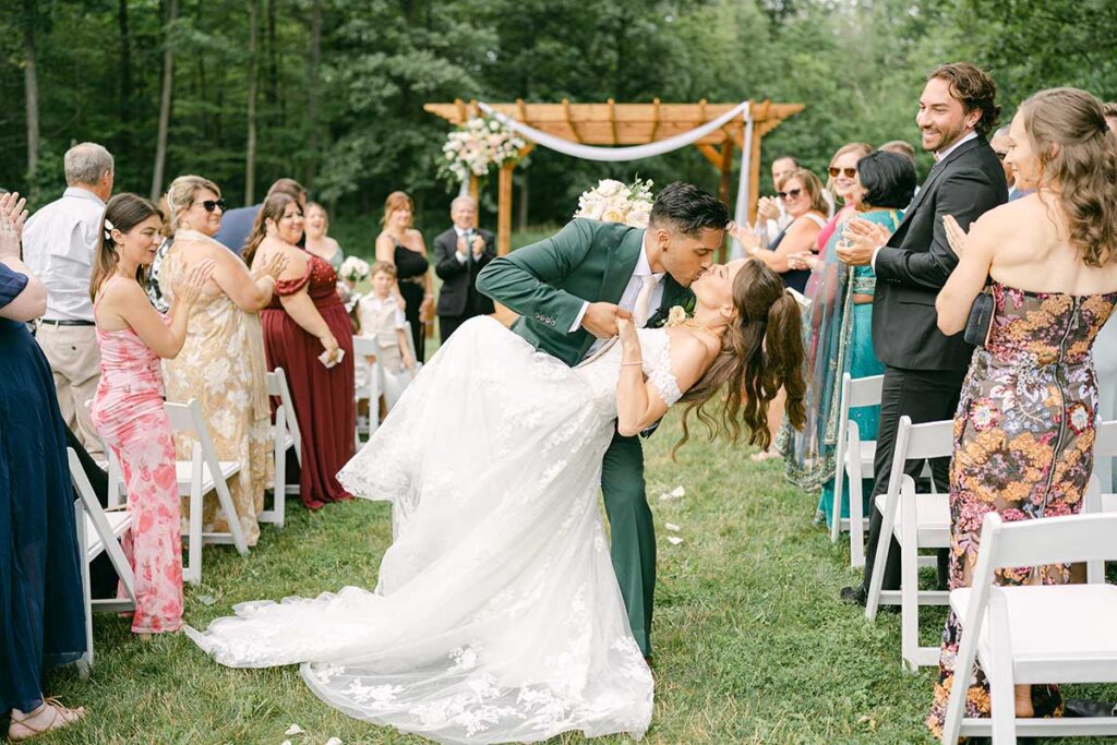 groom dipping bride at end of ceremony aisle