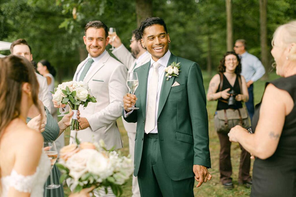 groom laughing holding glass of wine